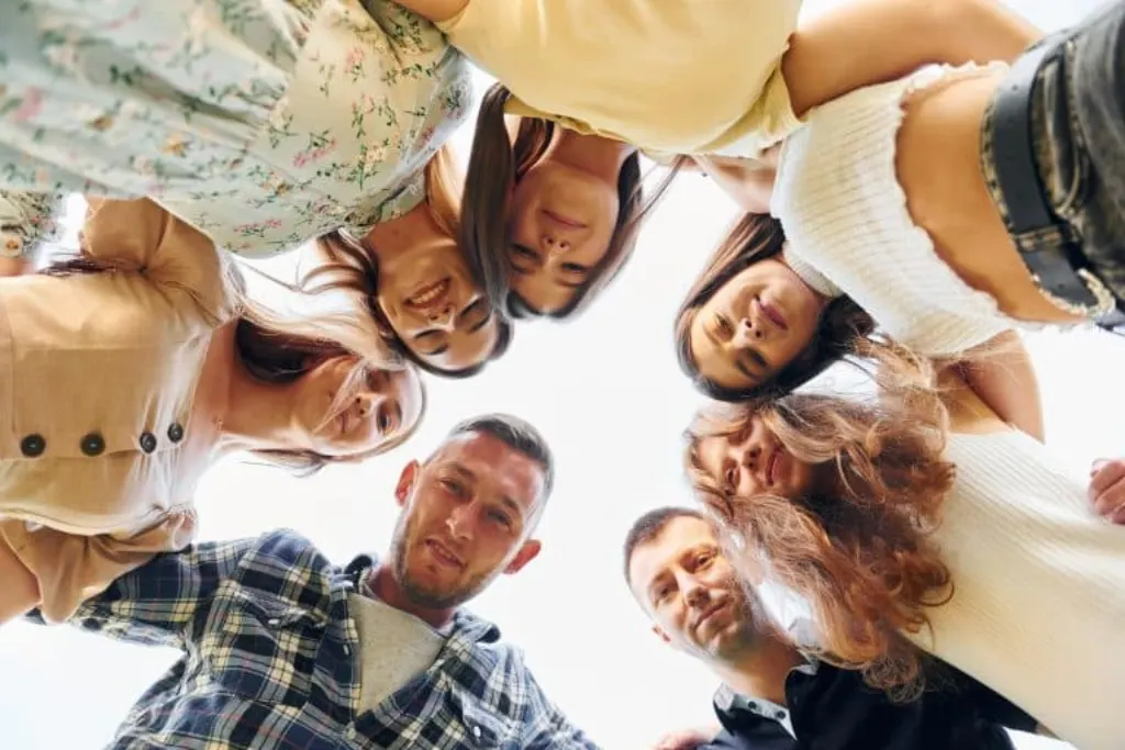 View from below of young positive people who looking down